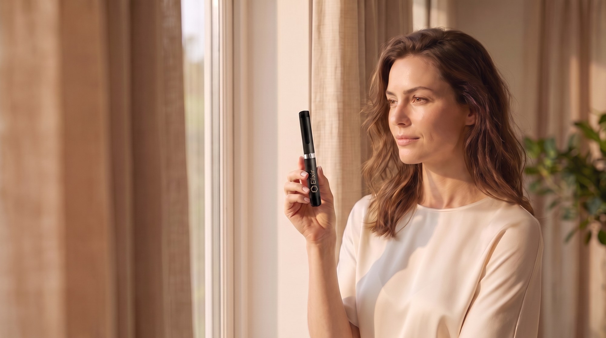 A woman in soft daylight holding the Elixir pen